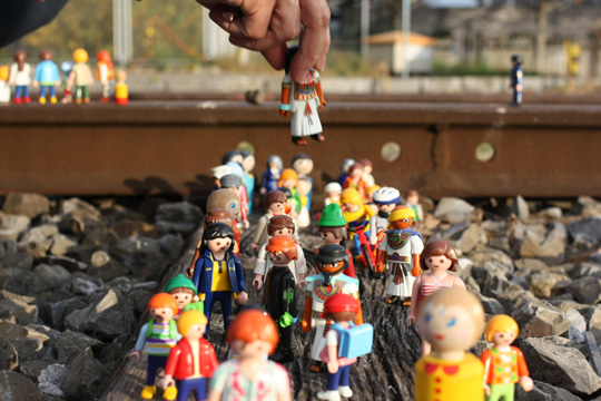 Eine Ansammlung von Playmobil-Figuren, platziert zwischen Bahnschienen auf der stillgelegten Bahntrasse des Hafenareals in Basel. Exemplifiziert den Aspekt Beratung, den Inés Mateos anbietet.